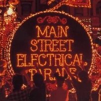 The Main Street Electrical Parade album cover: the parade's illuminated title drum glowing in orange lights above a crowd watching from Main Street at night